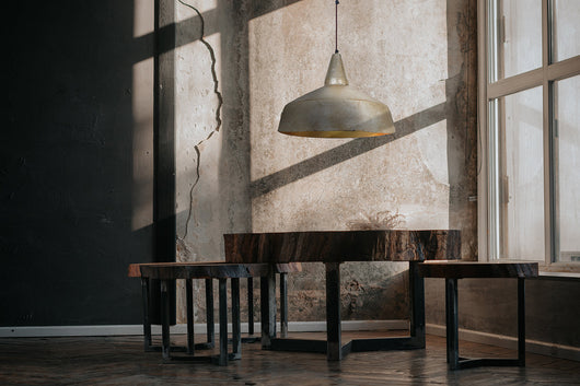 Ein stilvoller Blickfang: Die goldene Hängelampe im Industrial Design setzt Akzente und schafft eine besondere Atmosphäre.