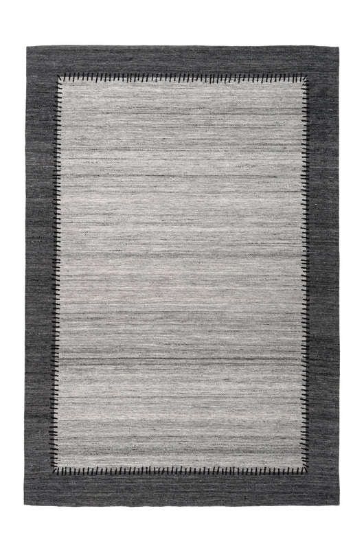 Der Teppich in Grau und Anthrazit besticht durch zeitloses Design. Hergestellt aus Wolle und Polyester, sorgt er für eine warme, weiche Oberfläche und ist pflegeleicht.