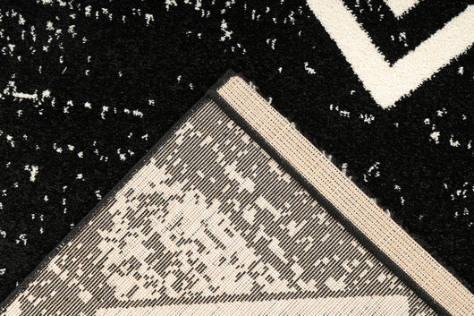 Moderner schwarzer Teppich mit geometrischem Muster im minimalistischen Interieur