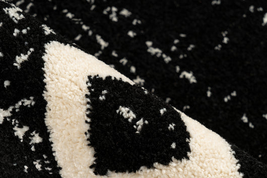 Schwarzer Kurzflor-Teppich auf Boden mit Fußbodenheizung und heller Einrichtung