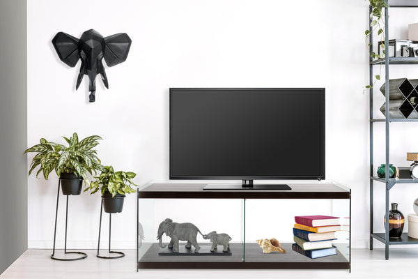 Dieser Fernsehtisch mit Glas Seitenwänden strahlt Eleganz und Transparenz aus. Das gehärtete Glas kontrastiert stilvoll mit den dunkelbraunen, matten Ablageflächen (MDF). Ein TV-Tisch der Serie Elementary, perfekt, um ein einheitliches Gesamtambiente zu schaffen.

